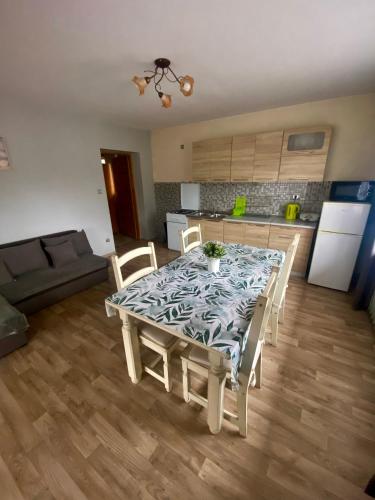 a dining room table with chairs and a kitchen at Pokoje z własnymi aneksami kuchennymi - Zbigniew Lassak in Biały Dunajec
