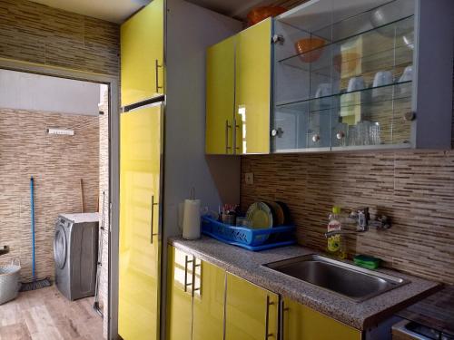 a kitchen with yellow cabinets and a sink at Le Loft 32 in Dakar