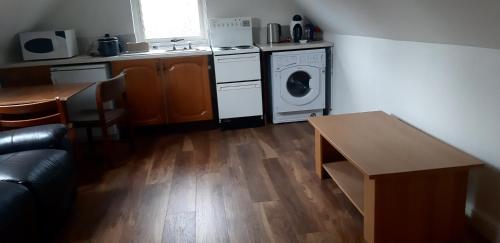 a kitchen with a stove and a washer and dryer at Spacious one bedroom apartment in North Kessock in Inverness