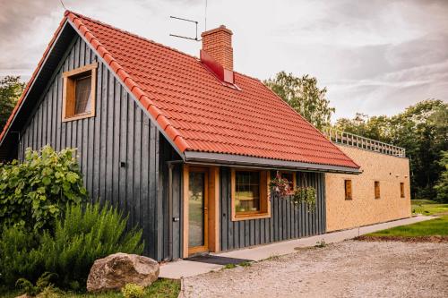 an orange roofed house with an orange roof at Brīvdienu māja ''Rātes'' Valmiermuiža in Valmiermuiža