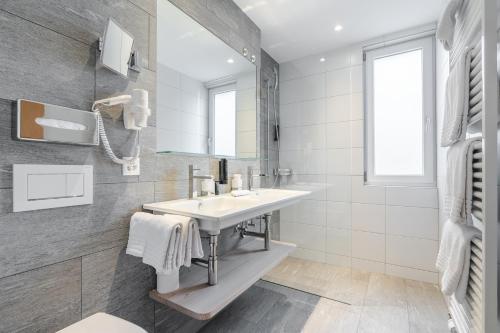 a bathroom with a sink and a mirror at Hotel Alpensonne - Panoramazimmer & Restaurant in Arosa
