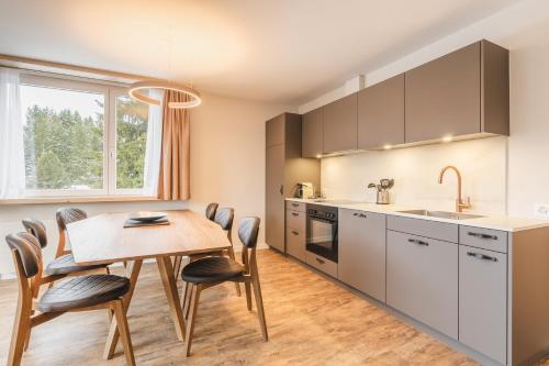 a kitchen and dining room with a table and chairs at Hotel Alpensonne - Panoramazimmer & Restaurant in Arosa