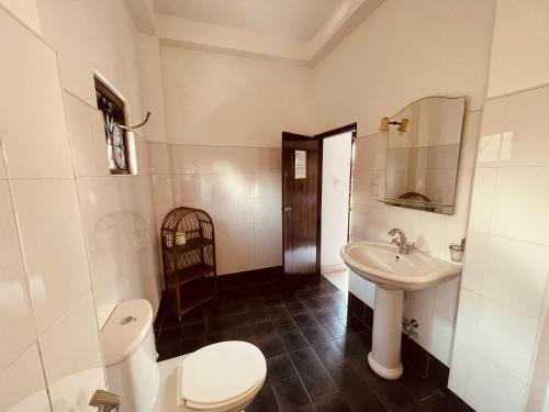 a bathroom with a toilet and a sink at Una Beach Hotel & OLU Cafe in Unawatuna