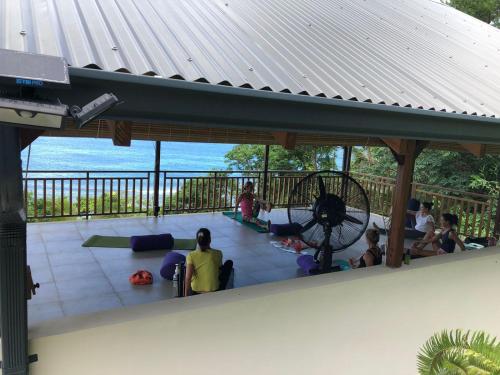 a group of people sitting on the porch of a building at Paradise Chalets Yoga & Wellness in Takamaka