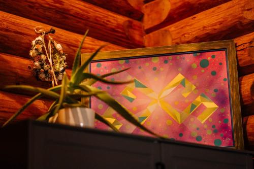 a tv screen with a plant on top of a cabinet at Brīvdienu māja ''Rātes'' Valmiermuiža in Valmiermuiža