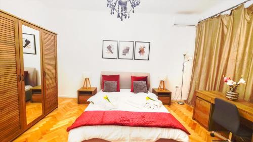 1 dormitorio con 1 cama grande con almohadas rojas en Spacious 5* luxury in historic center free parking, en Cluj-Napoca