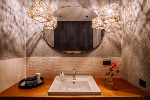 a bathroom with a sink and a mirror at Brīvdienu māja ''Rātes'' Valmiermuiža in Valmiermuiža