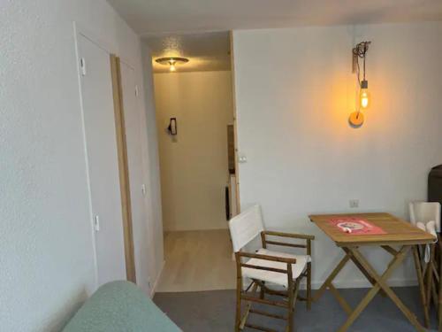 a room with a table and a table and chairs at Modern studio in the heart of the station 1650 in Les Orres