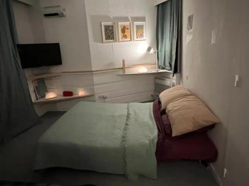 a small bedroom with a bed and a television at Modern studio in the heart of the station 1650 in Les Orres