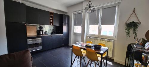 a kitchen with black cabinets and a table and chairs at Efeso 19 in Rome