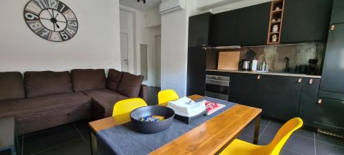 a living room with a table and yellow chairs at Efeso 19 in Rome