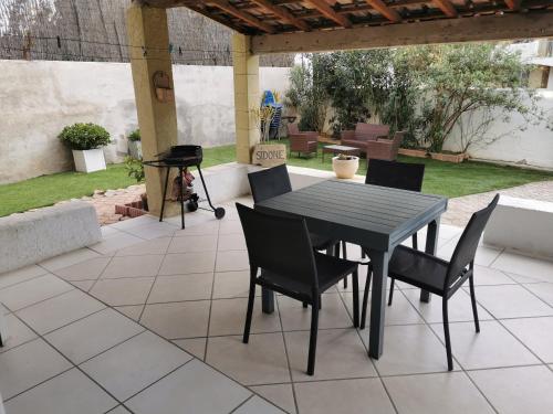 - une table et des chaises sur une terrasse avec barbecue dans l'établissement Maison Jardin+Jacuzzi l'été, plage à 1 km, à Marseille