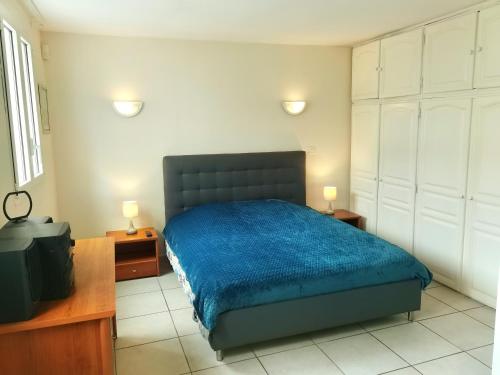 une chambre avec un lit avec une couette bleue dans l'établissement Maison Jardin+Jacuzzi l'été, plage à 1 km, à Marseille