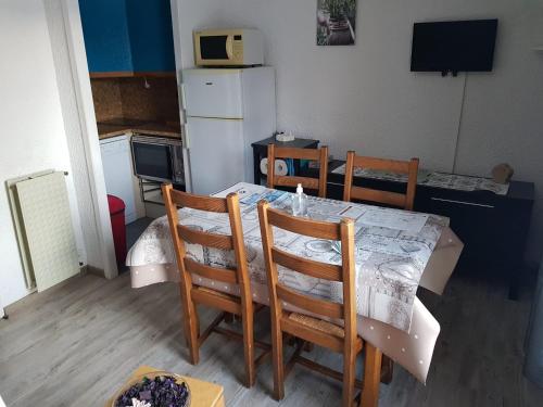 uma cozinha com mesa e cadeiras e uma cozinha com frigorífico em Studio pied des pistes 4 personnes em Les Deux Alpes