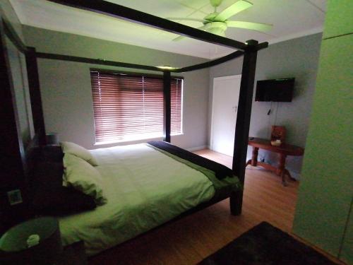 a bedroom with a canopy bed and a window at Protea Private Suite - Ramsgate Ramble Rest in Margate