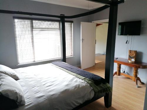 - une chambre avec un lit, un bureau et une fenêtre dans l'établissement Protea Private Suite - Ramsgate Ramble Rest, à Margate