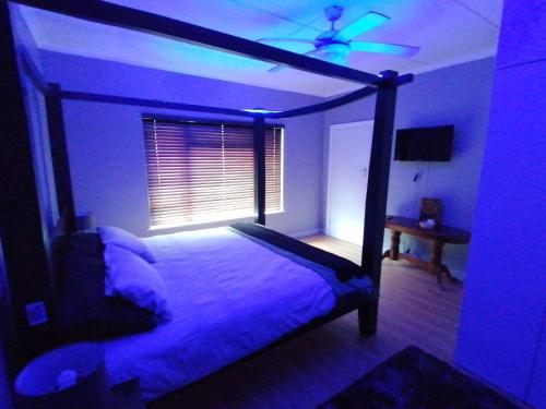 a bedroom with a bed with a ceiling fan at Protea Private Suite - Ramsgate Ramble Rest in Margate