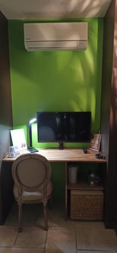 a desk with a monitor and a chair in a room at Villa SOREDE in Sorède