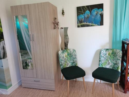 a room with two chairs next to a door at Gites "les colibris" in Schœlcher