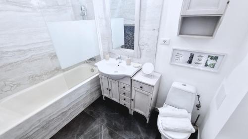 a white bathroom with a sink and a toilet at Spacious 5* luxury in historic center free parking in Cluj-Napoca