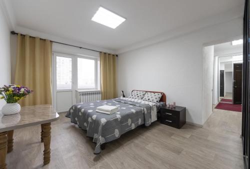 1 dormitorio con cama, mesa y ventana en Світла, комфортна квартира біля метро Мінська, en Kiev