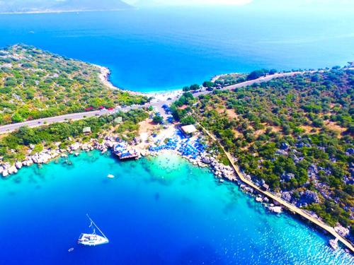 an aerial view of a beach with a boat in the water at James Pansiyon Blue sea view villas Kaş Peninsula in Kas