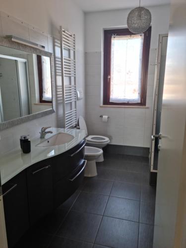y baño con lavabo, aseo y espejo. en CASA FLAN en Porto San Giorgio