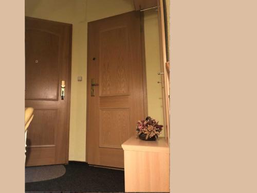 - un couloir avec deux portes en bois et un vase de fleurs dans l'établissement Ferienwohnung Sprenger _ Objekt 25, à Rostock