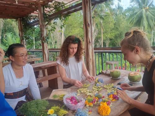Un groupe de femmes autour d'une table avec des fleurs dans l'établissement Bali Sesandan Garden, à Tabanan