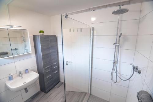 uma casa de banho com um chuveiro e um lavatório. em Ferienwohnung "elbRetreat" in Seevetal-Over an der Elbe - Stilvoll wohnen auf Zeit em Seevetal