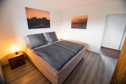 a bed in a room with two paintings on the wall at Ferienwohnung "elbRetreat" in Seevetal-Over an der Elbe - Stilvoll wohnen auf Zeit in Seevetal