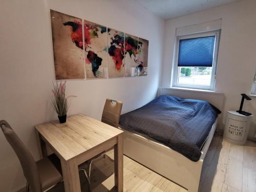 1 dormitorio con cama, mesa y ventana en Gemütliches Zimmer mit eigenem Bad und Küche, en Swisttal