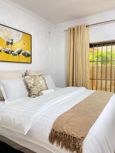 a bedroom with a large white bed with a window at Ranzi Court in Palatswe