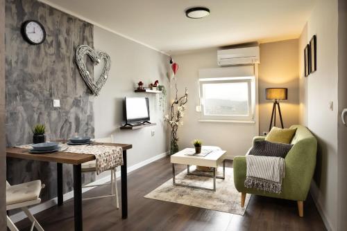 un soggiorno con tavolo e sedia verde di Apartment Viksa with Jacuzzi a Zagabria