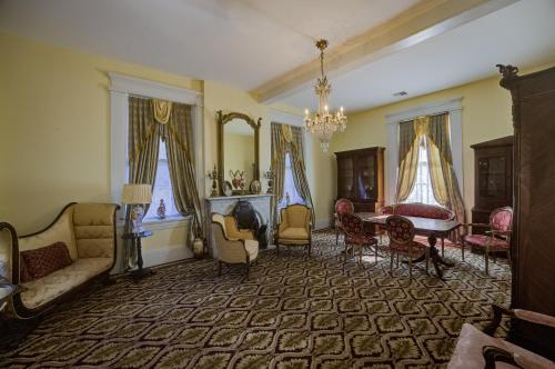 a living room with a couch and a table and chairs at The Inn at Cedar Grove in Vicksburg