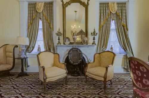 a living room with two chairs and a fireplace at The Inn at Cedar Grove in Vicksburg