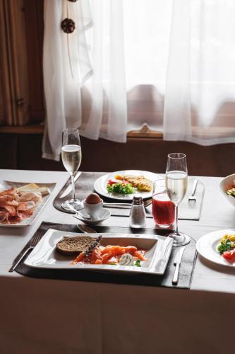 a table with plates of food and glasses of wine at Camana Veglia in Livigno