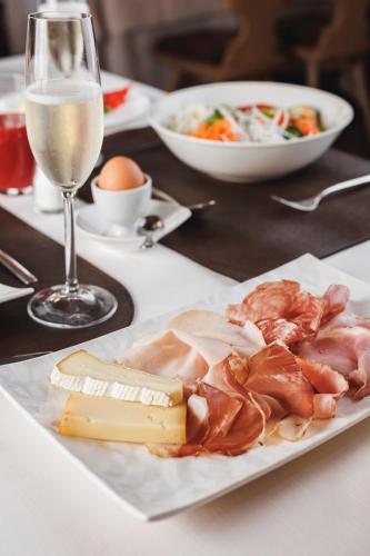 a plate of meat and cheese and a glass of wine at Camana Veglia in Livigno