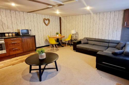 uma sala de estar com um sofá e uma mesa em The Birch Cabin with hot tub em Bristol