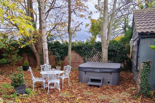 a backyard with a table and chairs and a grill at The Birch Cabin with hot tub in Bristol