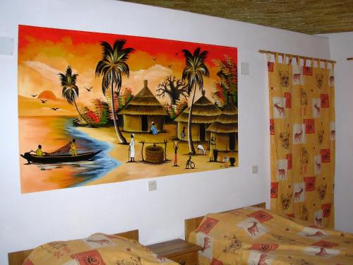 a painting on the wall of a room with two beds at le baobab de nianing in Nianing