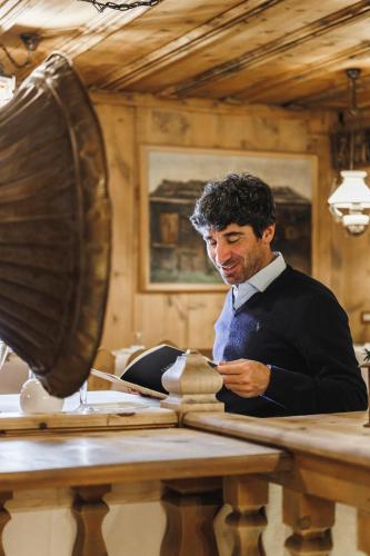 a man in a suit sitting at a table at Camana Veglia in Livigno