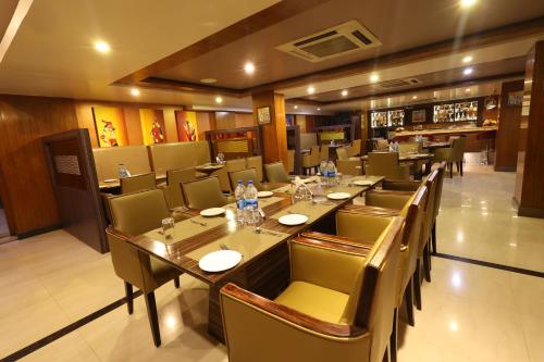 a restaurant with a long table and chairs at Akash Inn in Shimoga