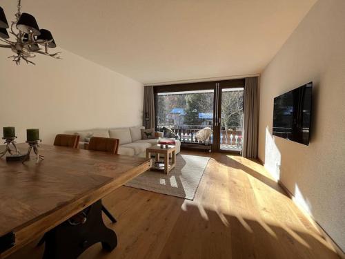 a living room with a couch and a table at Cozy apartment during WEF Davos 2026 in Klosters