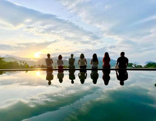 a group of people sitting around a pool watching the sunset at Lua Pu Luong in Pu Luong