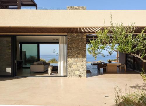 a house with a patio with a view of the ocean at Nuez Villas in Mochlos