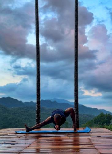 a woman doing a yoga pose on a wooden deck at Lua Pu Luong in Pu Luong