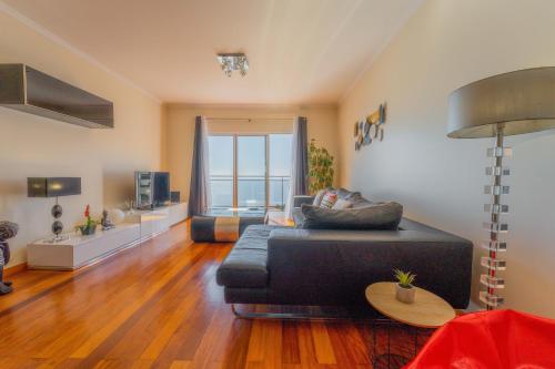 una sala de estar con un sofá y una mesa en FLH Garajau Fantastic Ocean View with Balcony, en Funchal