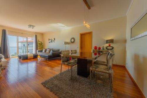 a living room with a table and a couch at FLH Garajau Fantastic Ocean View with Balcony in Funchal