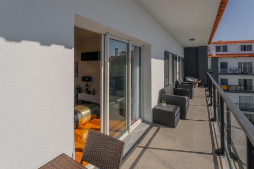 a balcony of a building with chairs and a living room at FLH Garajau Fantastic Ocean View with Balcony in Funchal